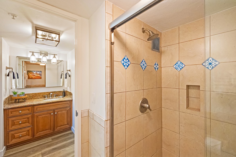 The spacious tiled shower at Mahana 1118 offers elegant finishes and a relaxing ambiance.