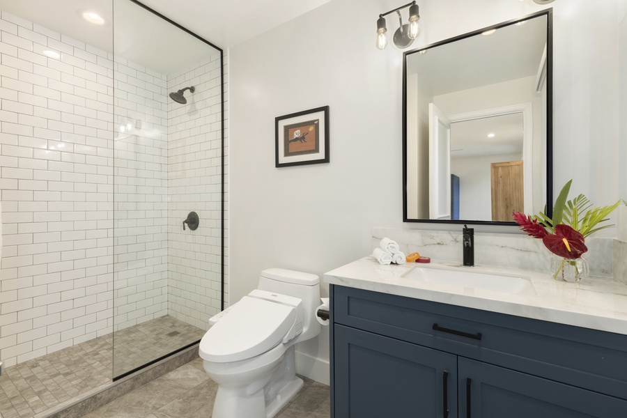 Private ensuite with a single vanity and walk-in shower.