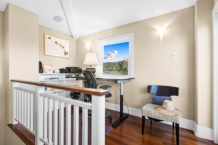 Upstairs office nook with workstation and window views.