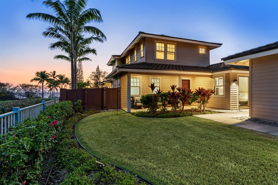 Lush green yard and twilight skies welcome you home.