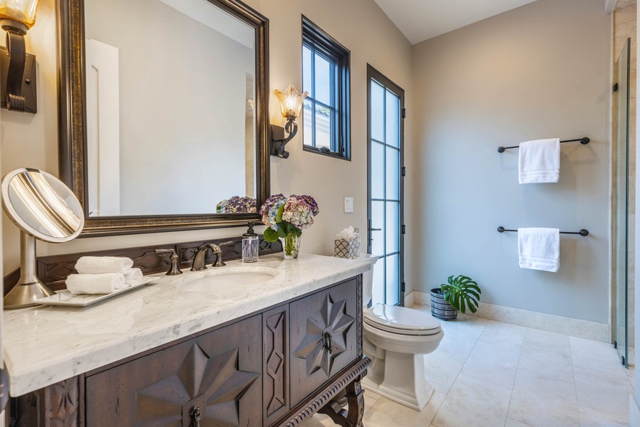 Elegant bathroom featuring a classic vanity, natural light, and tasteful decor.