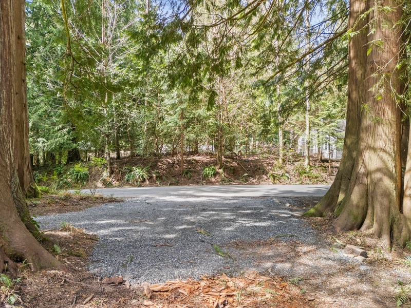 Convenient off-street parking framed by evergreens ensures easy arrivals and departures.