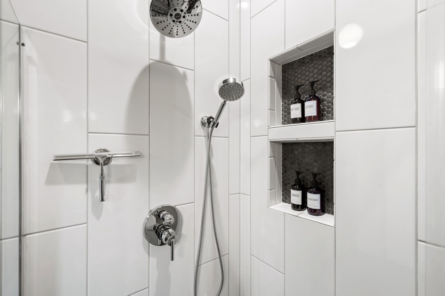 Refresh in a bright, tiled walk-in shower with sleek built-ins for your essentials.