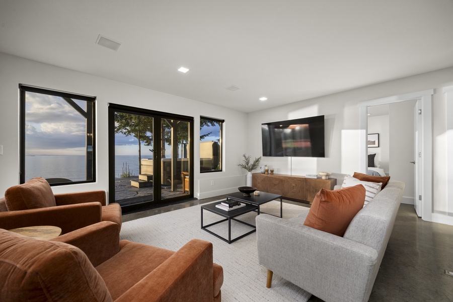 Lower-level lounge with comfortable seating and TV — perfect for movie nights or relaxed family gatherings.