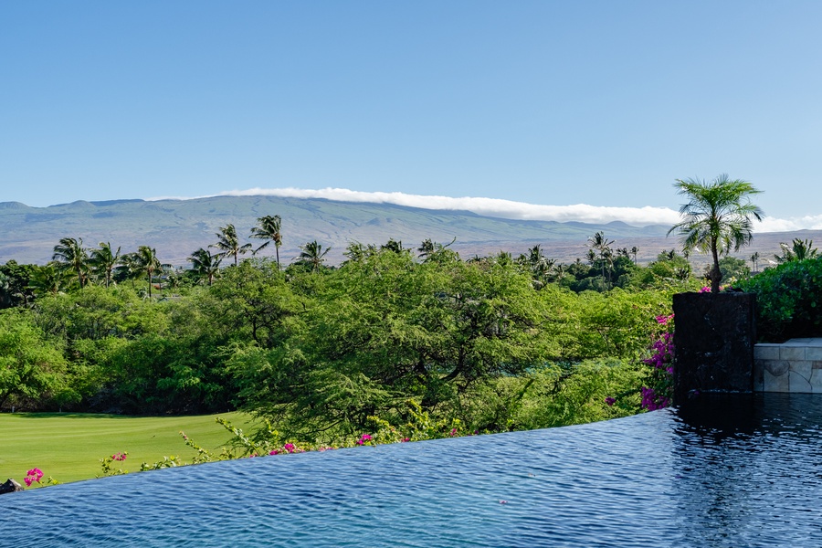 Infinity pool with stunning views of lush greenery and distant mountains, creating a peaceful and serene setting.