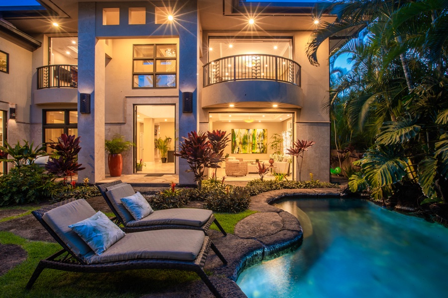 Evening ambiance around the pool with loungers and warm glow.