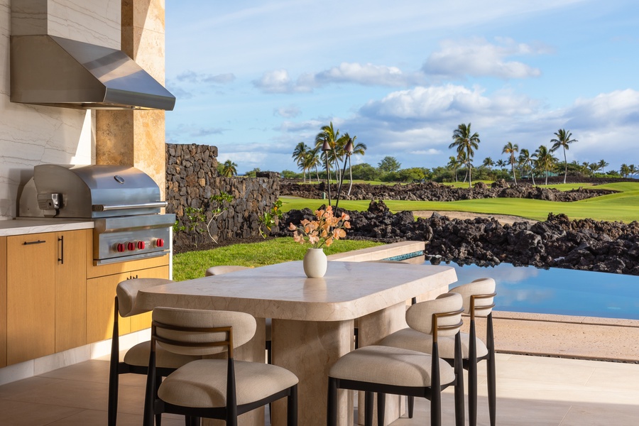 Gather for a meal with a view by the poolside dining area, complete with outdoor kitchen.