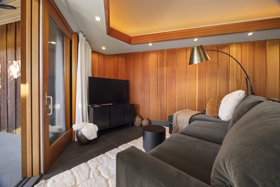 Sink into plush seating surrounded by warm wood paneling and modern comforts in your stylish entertainment space.
