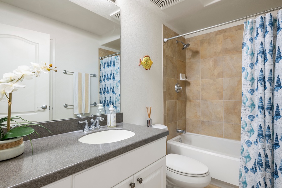 Refresh in your bright bathroom with coastal touches and modern amenities for a comfortable stay.