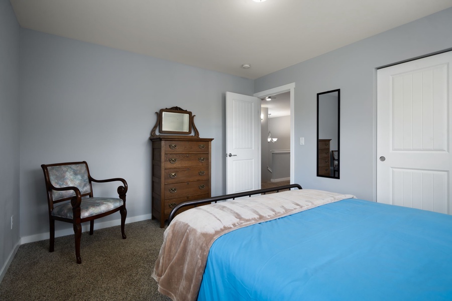 A spacious guest bedroom with cozy furnishings and soft lighting creates the perfect place to recharge and unwind.