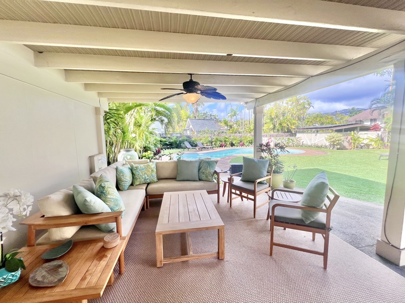 Cozy lanai with plush seating and a relaxing garden view—perfect for unwinding outdoors.