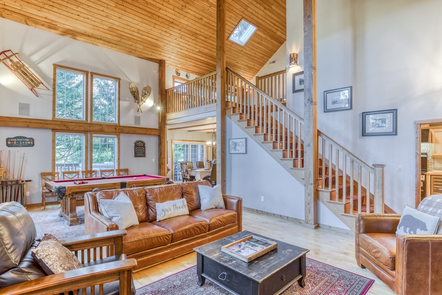 The living area features lofted ceilings, a walk-out to the deck and open stair to the upper floor.