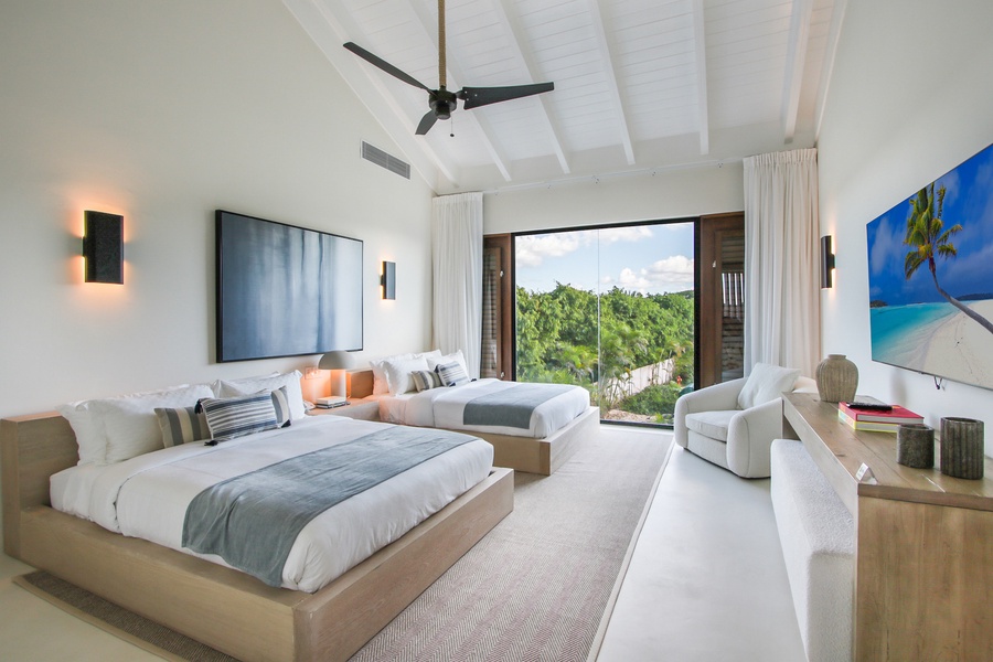 Cozy guest bedroom with two beds and garden views.