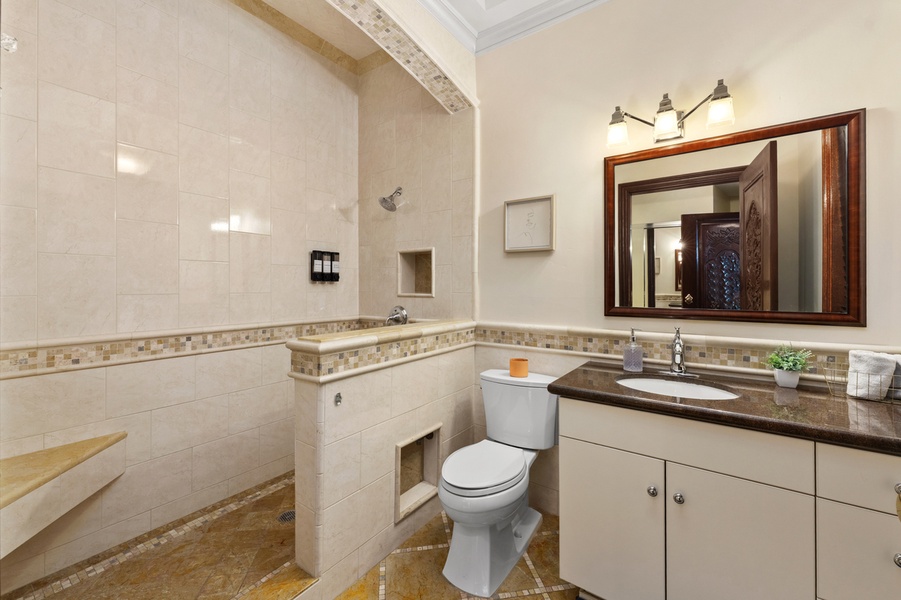 A wide vanity and a glass shower, bright enough to start the day.