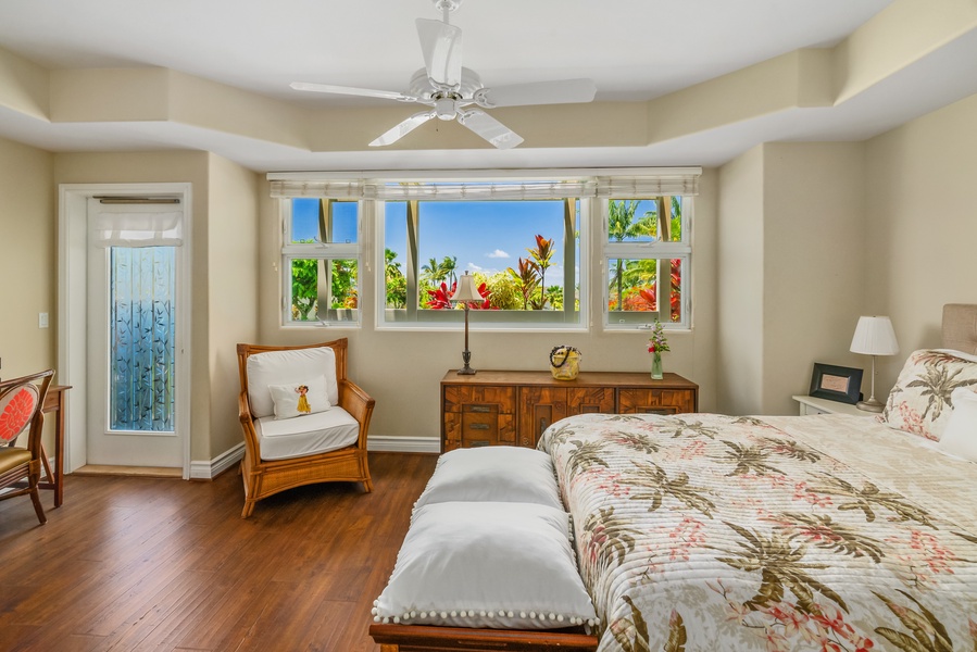 Lower level suite with plush bed and luxury linens, and private lanai offering a glimpse of the enchanting ocean.
