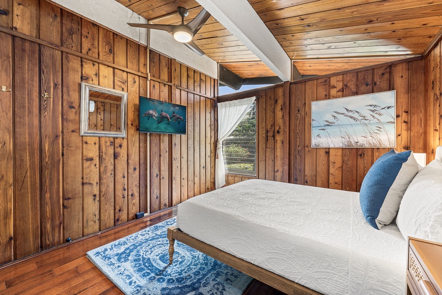 Sink into quaint-luxury in your bedroom, where exposed beams and ocean artwork create a cozy coastal retreat for peaceful nights.