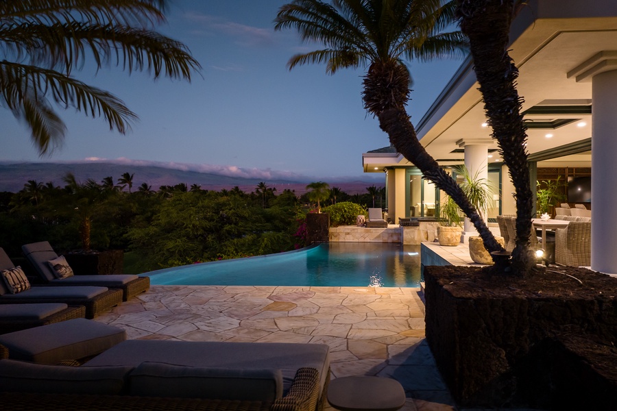 Infinity pool with soft evening lighting and lush surroundings.