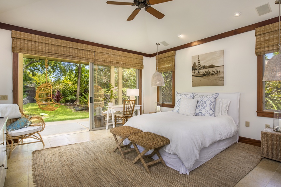 The elegant fourth bedroom (Ohana suite) features a queen bed & private lanai with two hanging chairs & a daybed