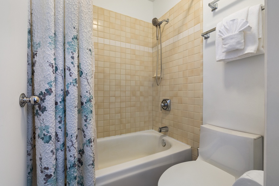 Step into your private bathroom featuring a relaxing tub-shower combo with fresh towels and all essentials ready for your stay.