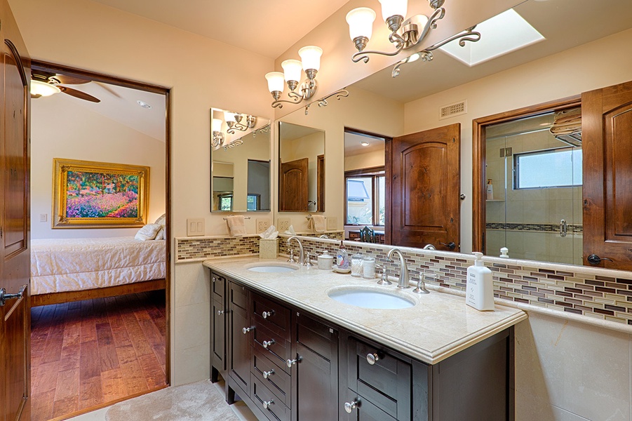 Guest bathroom shared between guest rooms with double sinks, private shower and toilet area