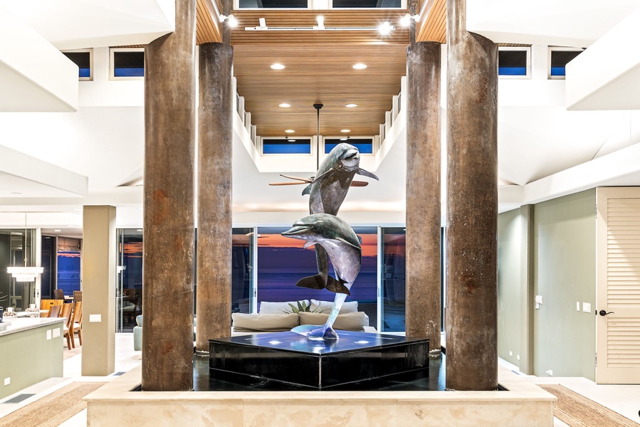 Step into a grand foyer where modern elegance meets artistic flair, featuring soaring ceilings and a stunning dolphin sculpture centerpiece.