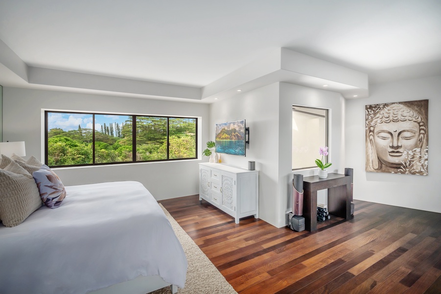 Bright bedroom with hardwood floors and expansive windows, offering both comfort and style.