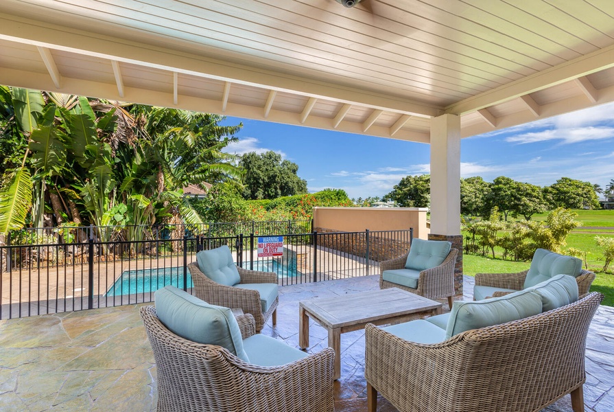 Comfortable outdoor lounge at Pohaku Villa with wicker seating, perfect for sunset cocktails.