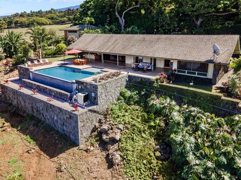 Aerial view of the charming home and the pool.