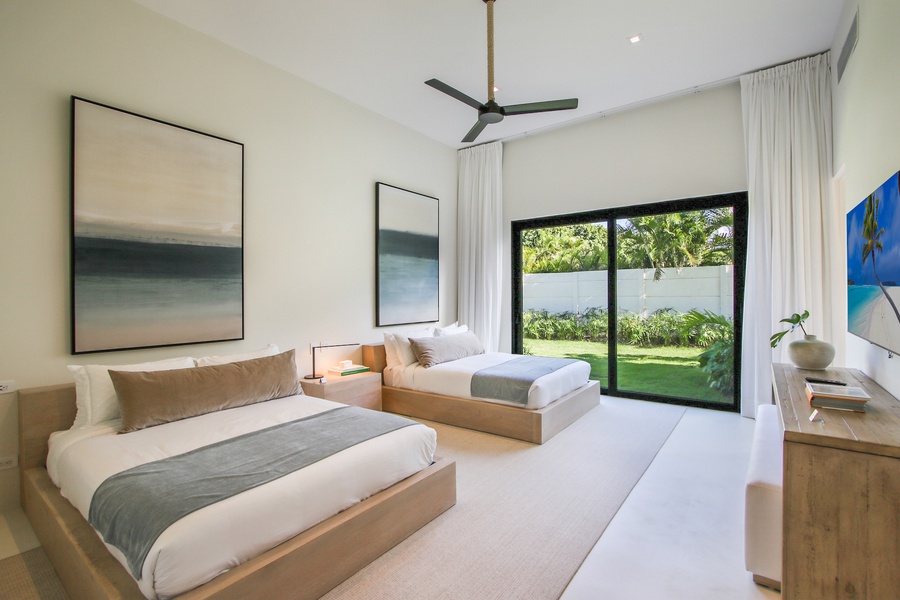 Bright guest bedroom with modern art and two cozy beds.