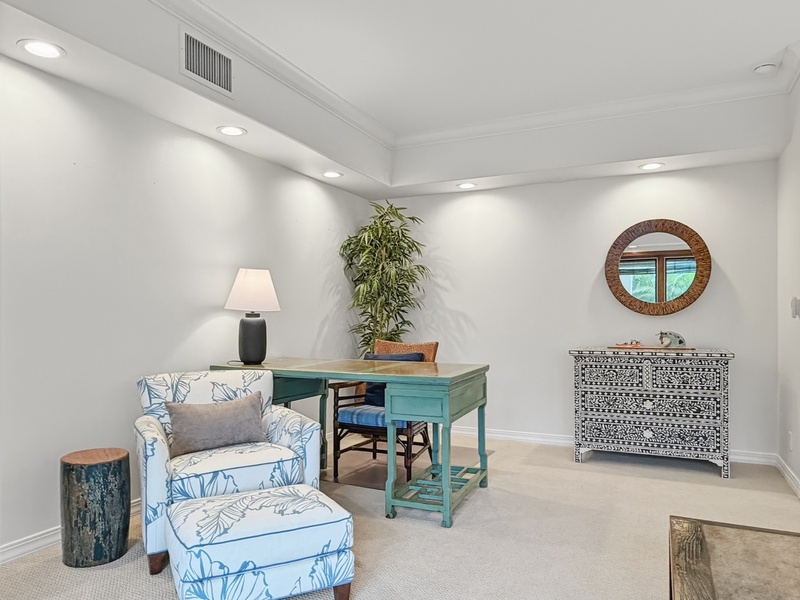 Your private workspace awaits with coastal charm—sink into the comfortable reading chair or settle at the turquoise desk for productive mornings.