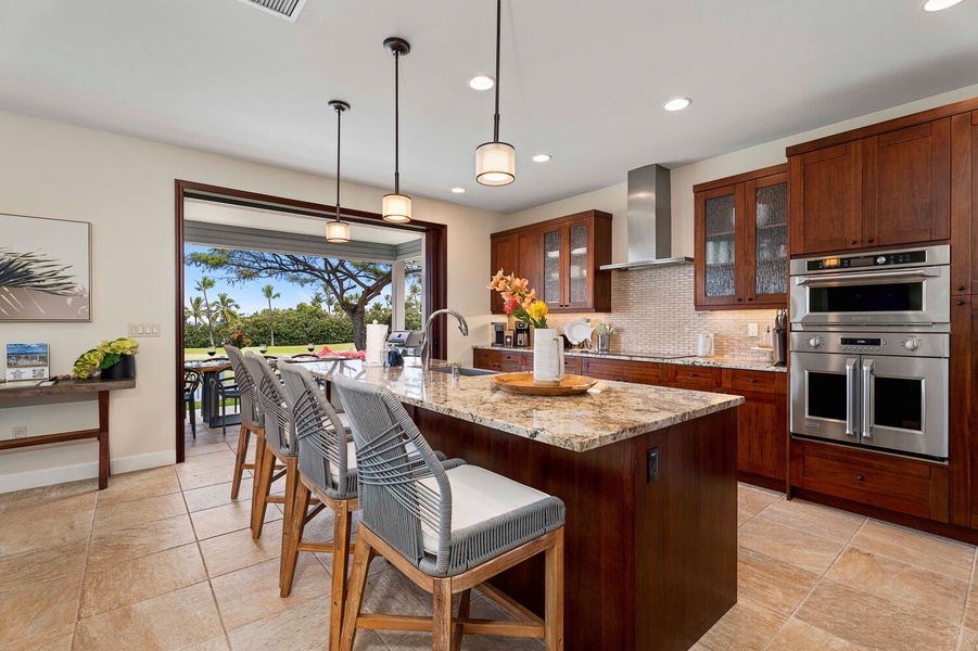Spacious kitchen with bar seating and an open view to a sunny golf course.