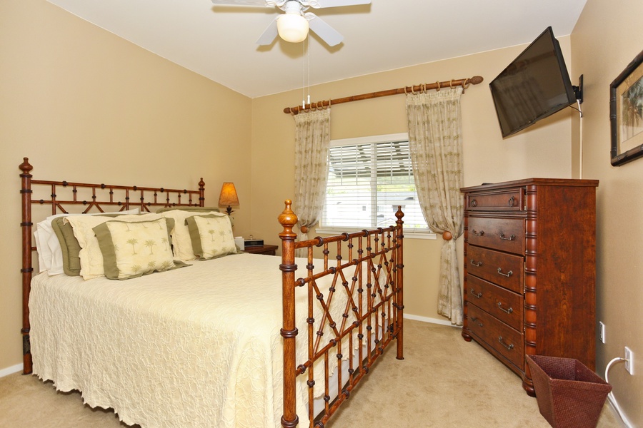 The second guest bedroom with a dresser and television.