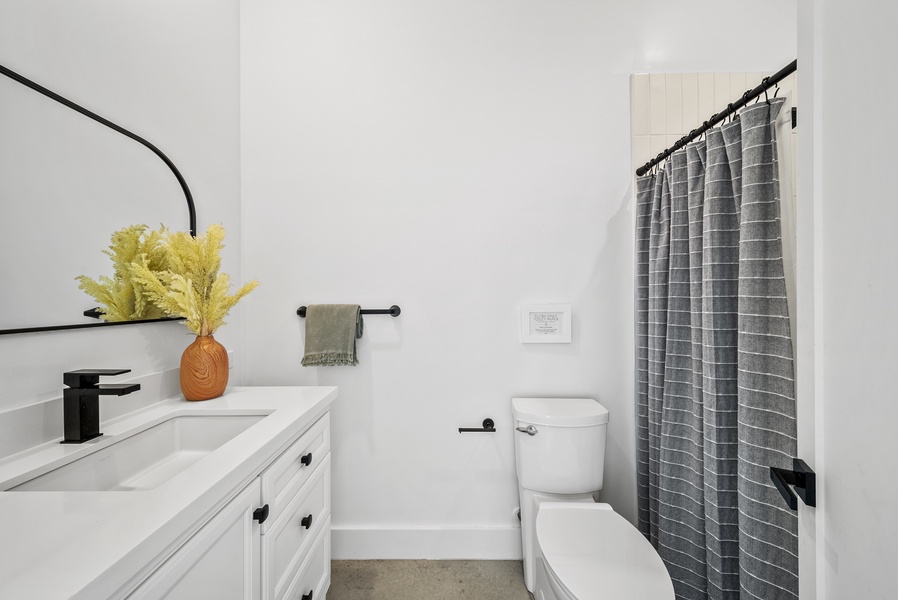 The ensuite bathroom has a single vanity and a separate shower for a spa-like feel.