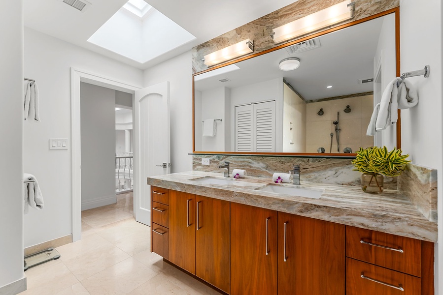 Dual vanity, rich wood cabinetry, and natural light create a serene setting for morning routines.
