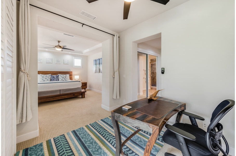 Spacious primary bedroom work space and king size bed