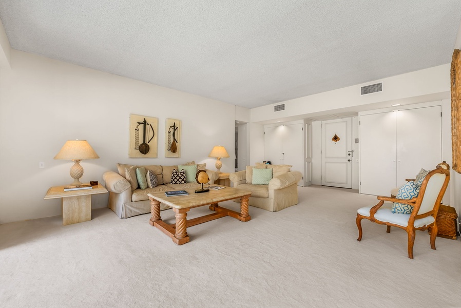 The spacious living area has plush sofas and direct access to the balcony.