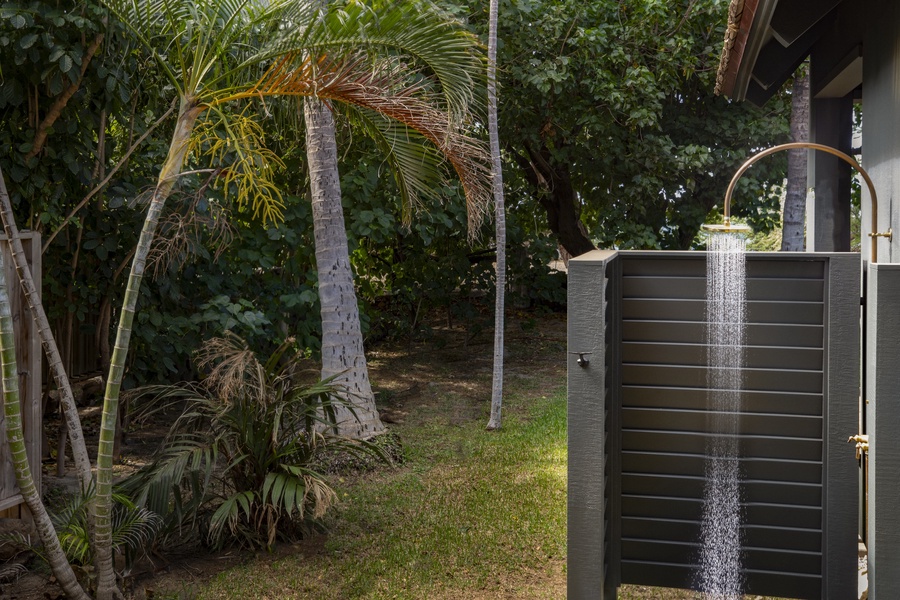 Private outdoor shower surrounded by tropical foliage for a unique experience.