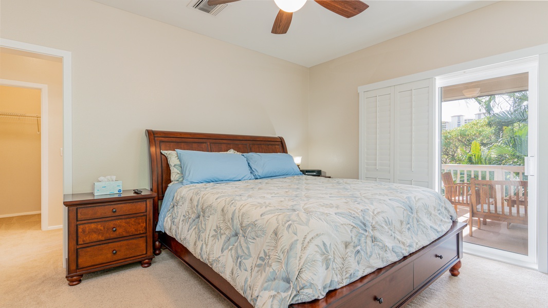The upstairs primary guest bedroom has soft linens and a ceiling fan.