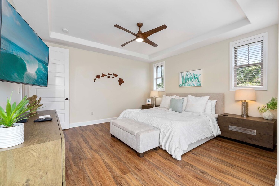 Bright and airy primary bedroom with minimalist decor and rich hardwood flooring.