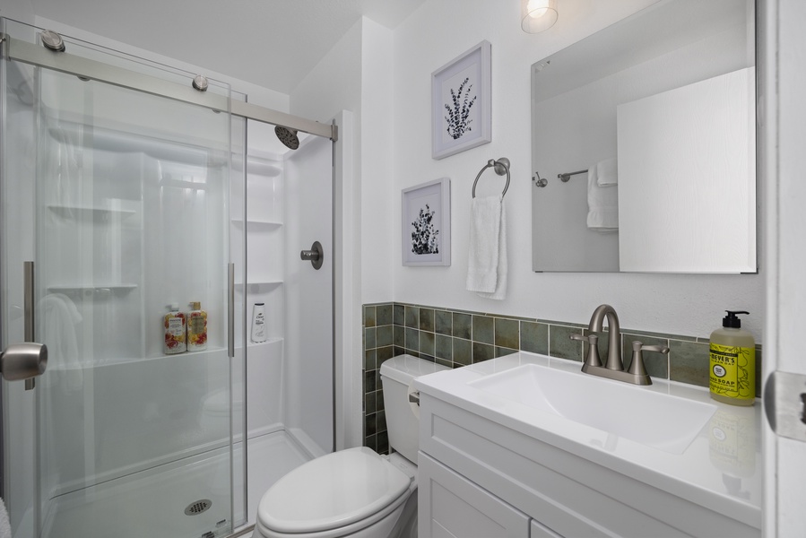 Second bathroom includes a sleek glass-enclosed shower and modern vanity for added comfort.