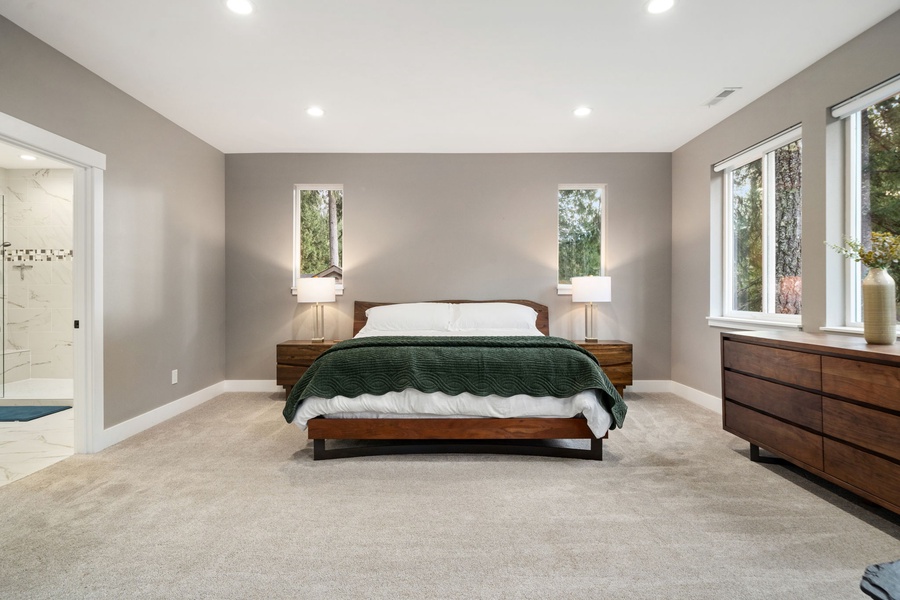 Sink into this primary bedroom where soft gray walls and plush carpeting create your peaceful retreat after exploring the day.