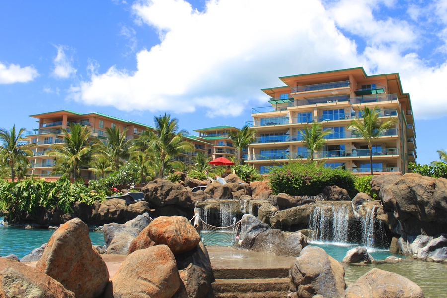 This stunning tropical oasis features cascading waterfalls surrounded by lush greenery and rock formations.