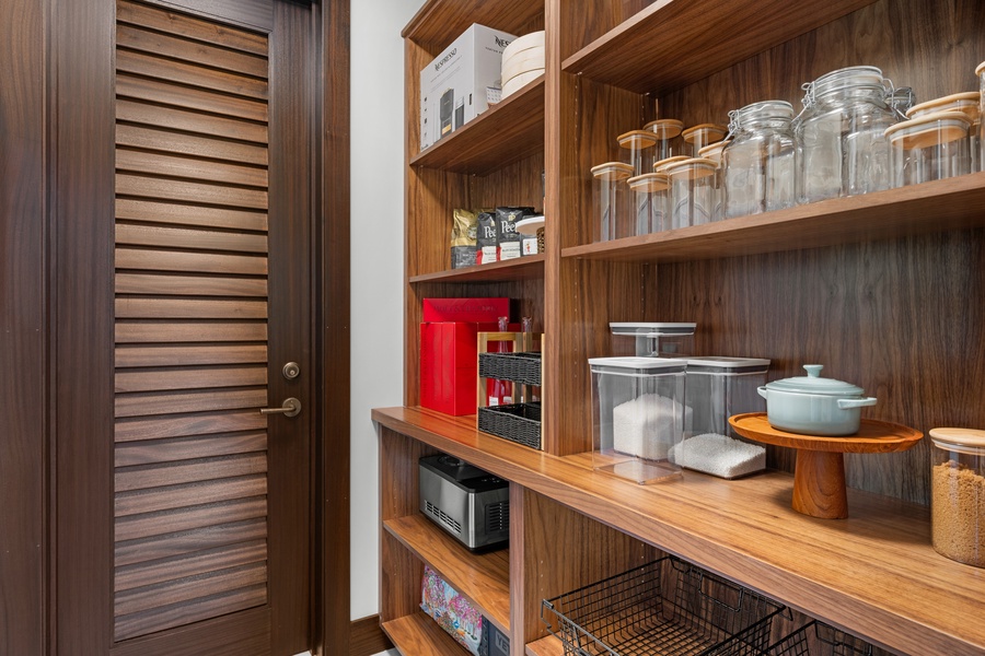 Your pantry features warm wood shelving with storage jars and modern appliances for convenient meal prep.