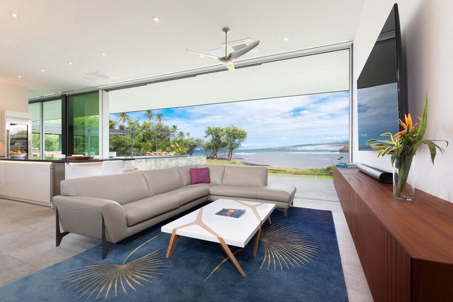 This open media space offers stunning ocean views through expansive sliding glass doors.