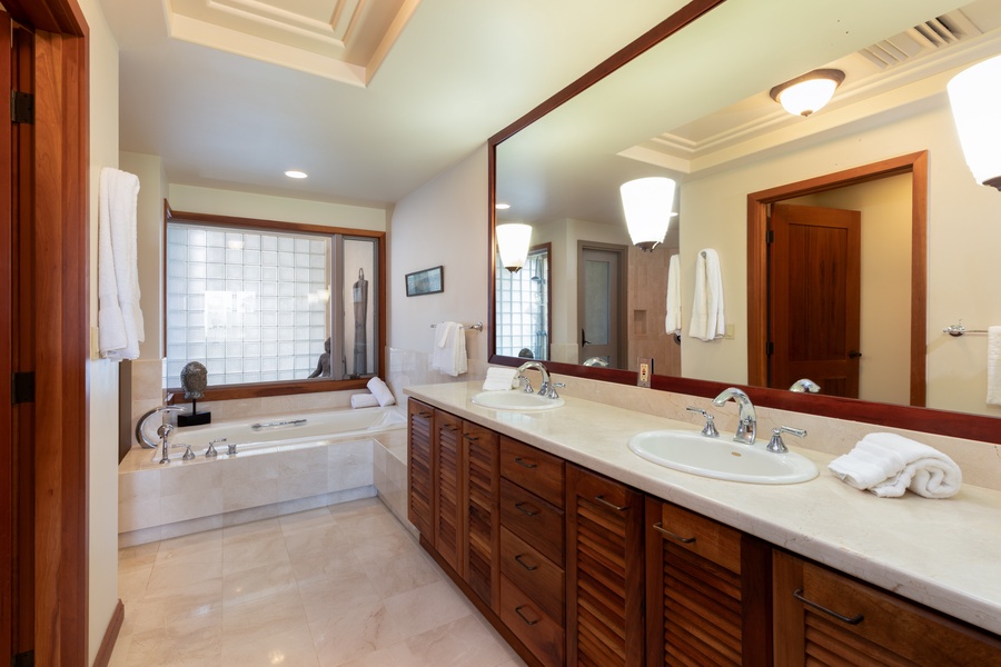 Unwind in your spacious primary bathroom with dual vanities, marble countertops, and a sleek soaking tub for ultimate relaxation.