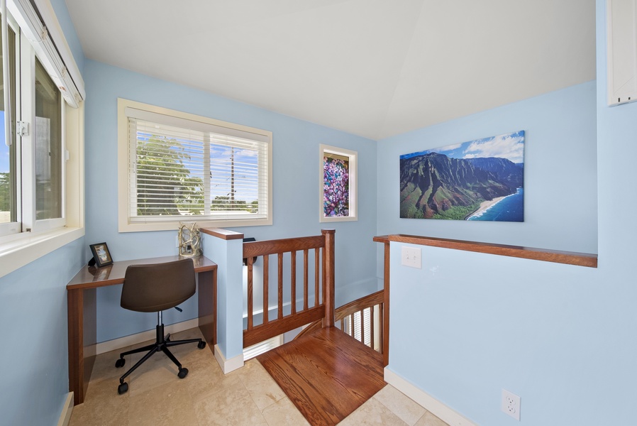 Going up the custom spiral staircase you come to the main bedroom loft featuring a desk area