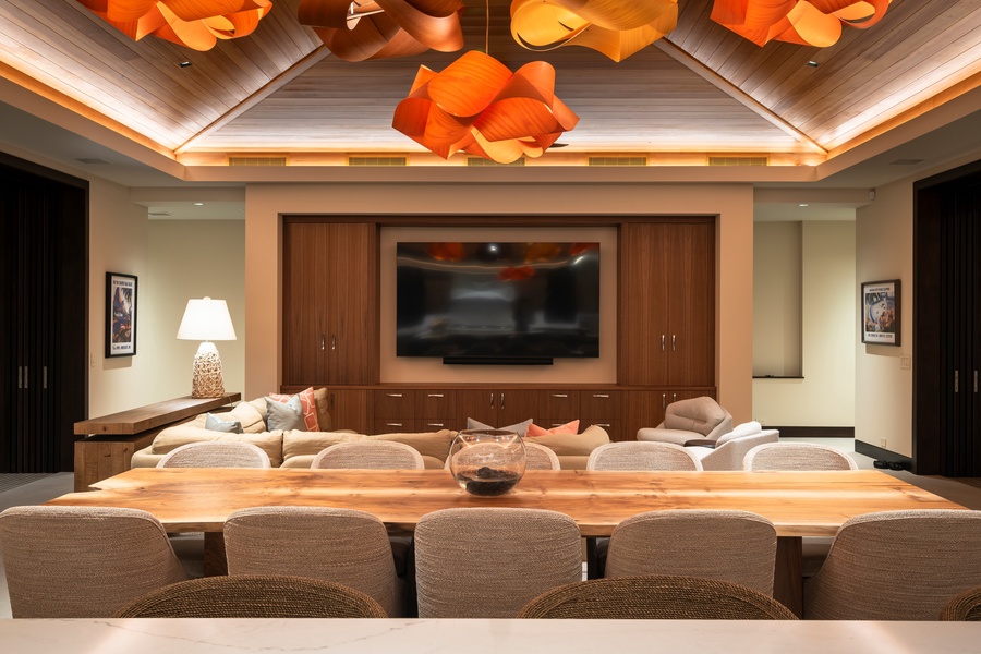 Gather around your grand dining table while enjoying the entertainment center's large screen TV and stunning sculptural lighting overhead.