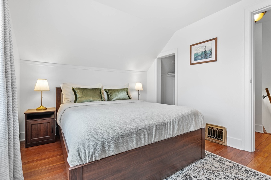 The upstairs king bedroom offers plush comfort, natural light, and an inviting space to recharge.