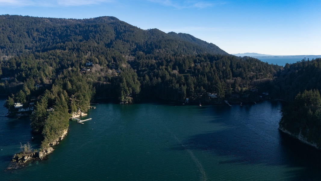 Pristine lake nestled among forested mountains creates a stunning natural backdrop for the surrounding area.