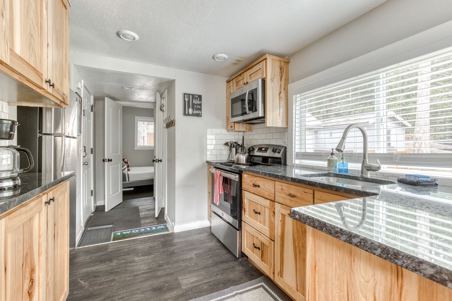 The kitchen has all stainless steel appliances, ample counter space, and views from the yard